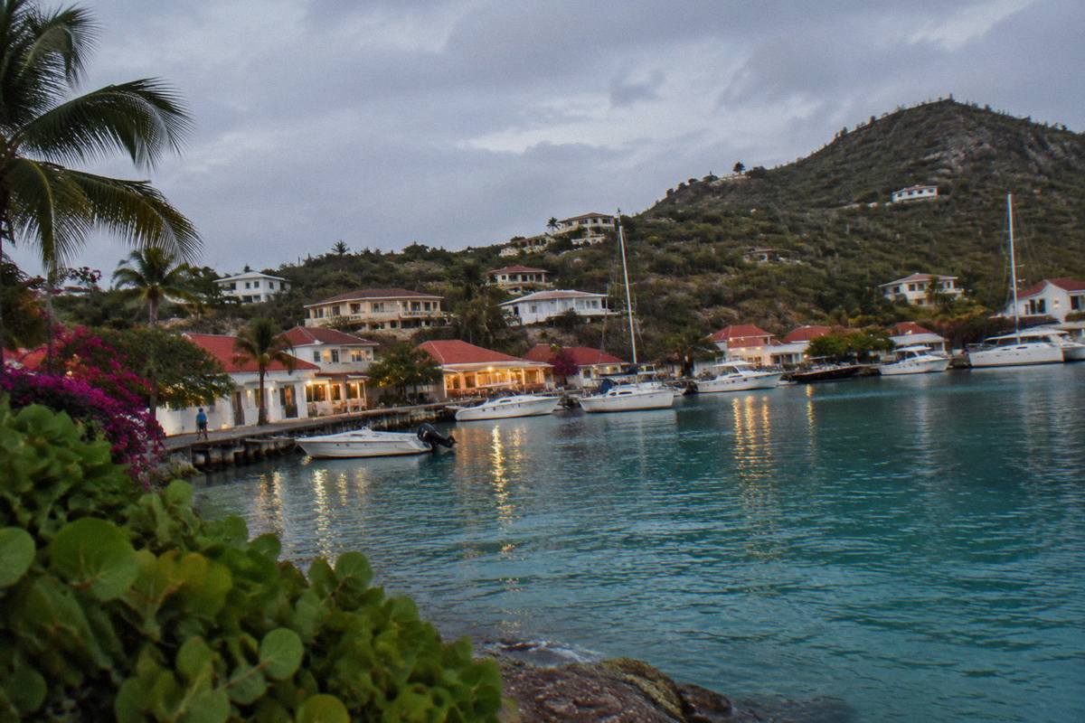 Harbourfront buildings with lit windows above boats moored at dusk