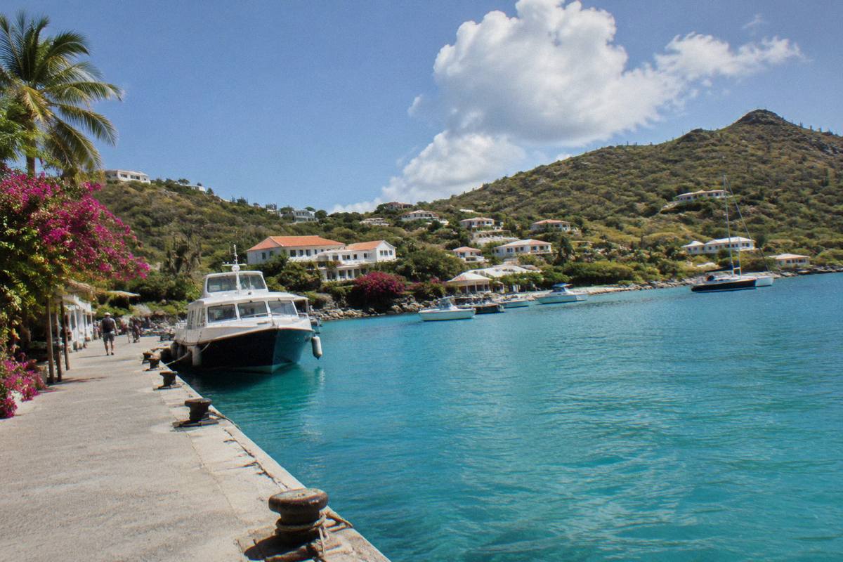 A ferry terminal quay beside calm turquoise water with moored boats