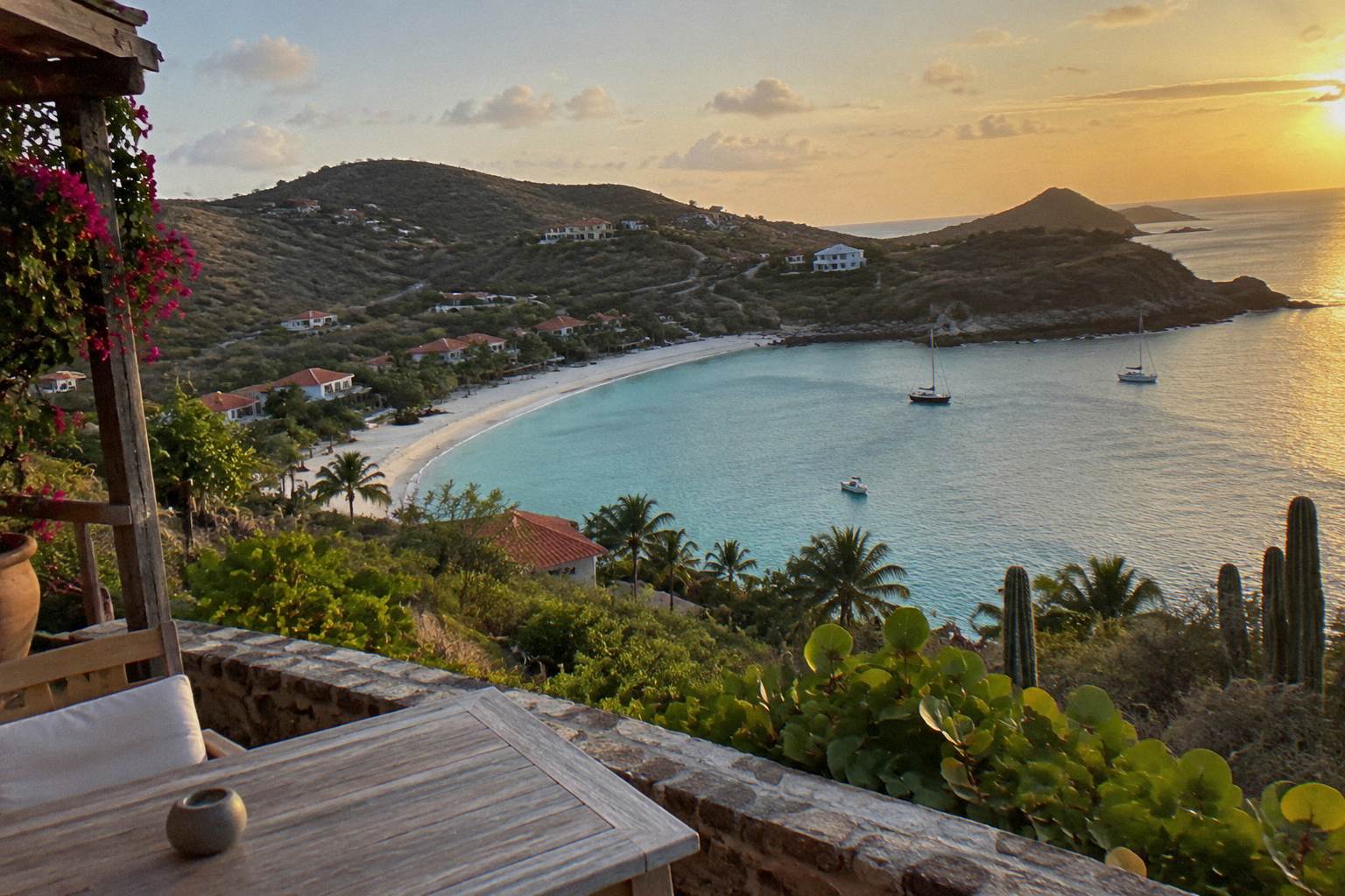 Quiet hotel terrace above a turquoise bay with white sand and green hills