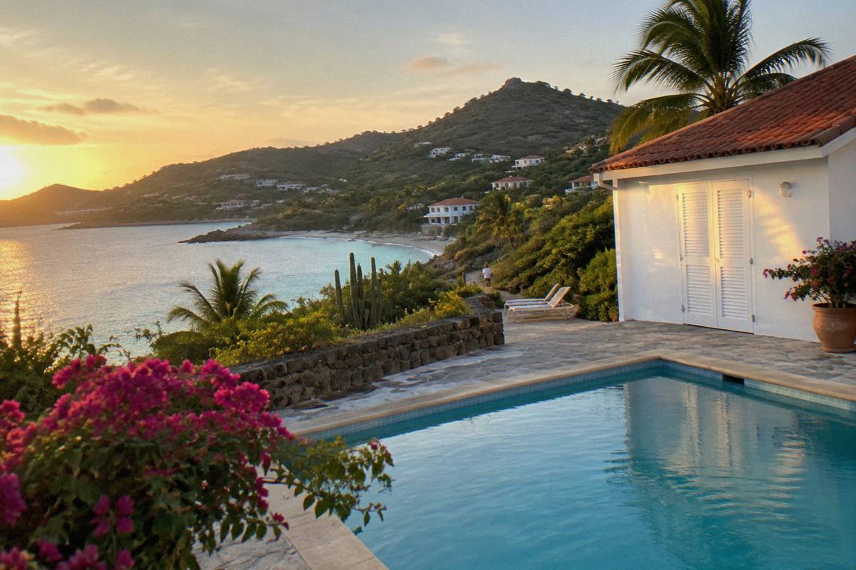 Shutters closed on a small Caribbean hotel building beside an empty swimming pool