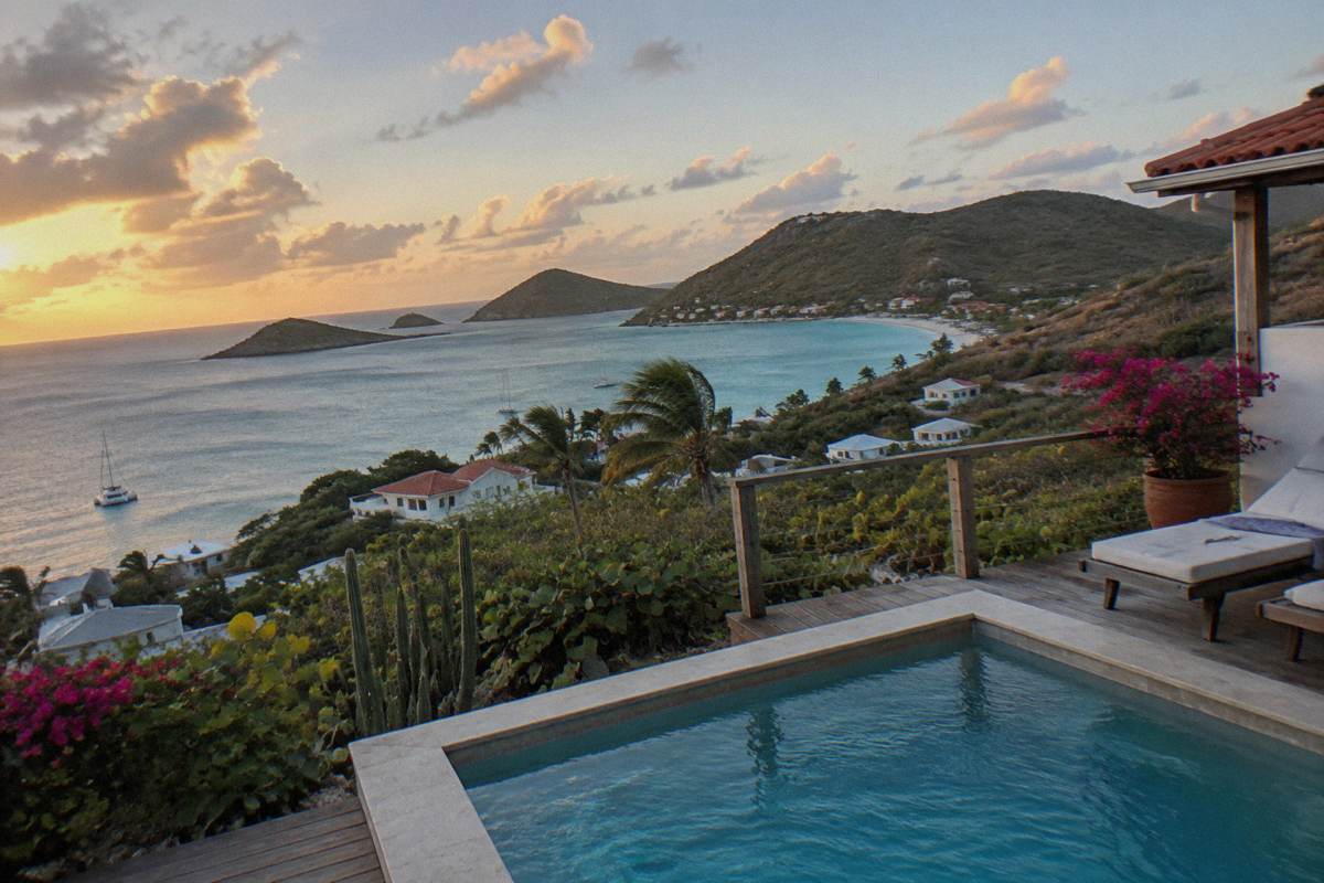 A private villa terrace with a plunge pool overlooking a calm bay at dusk