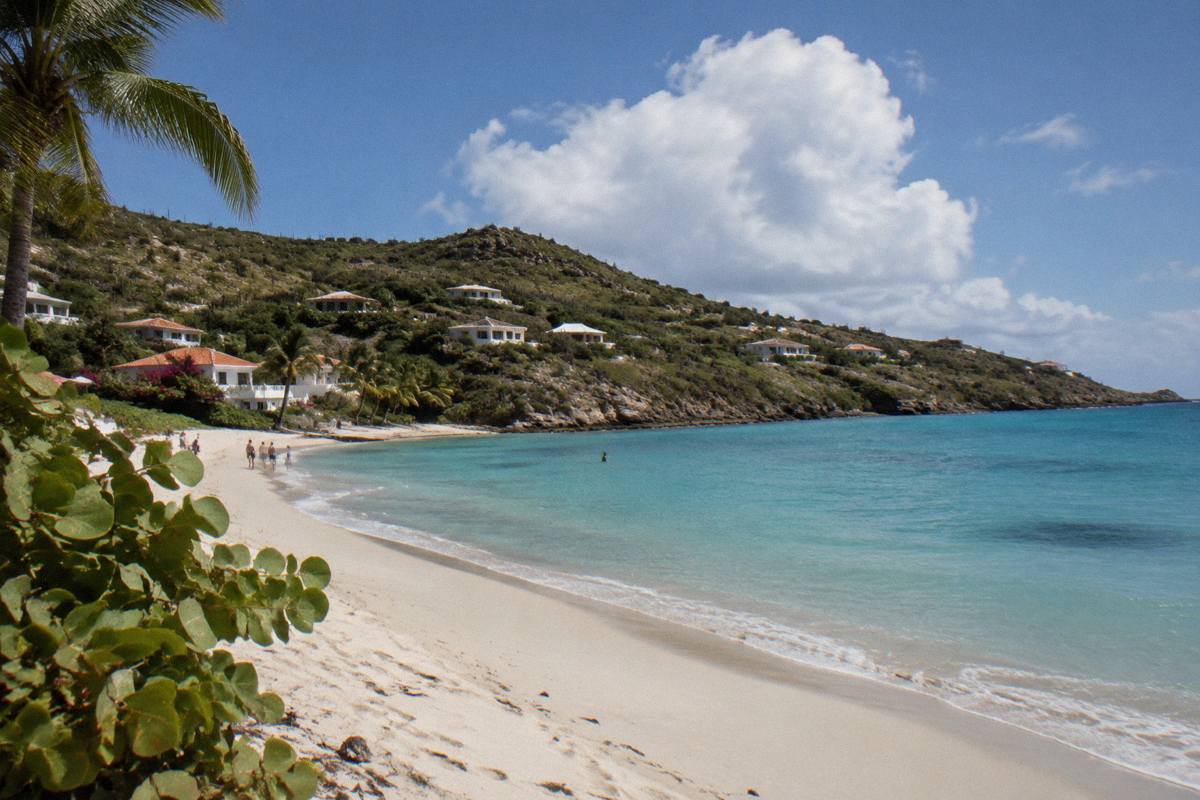 White sand beach with calm turquoise water and wooded headland in Saint Barthelemy