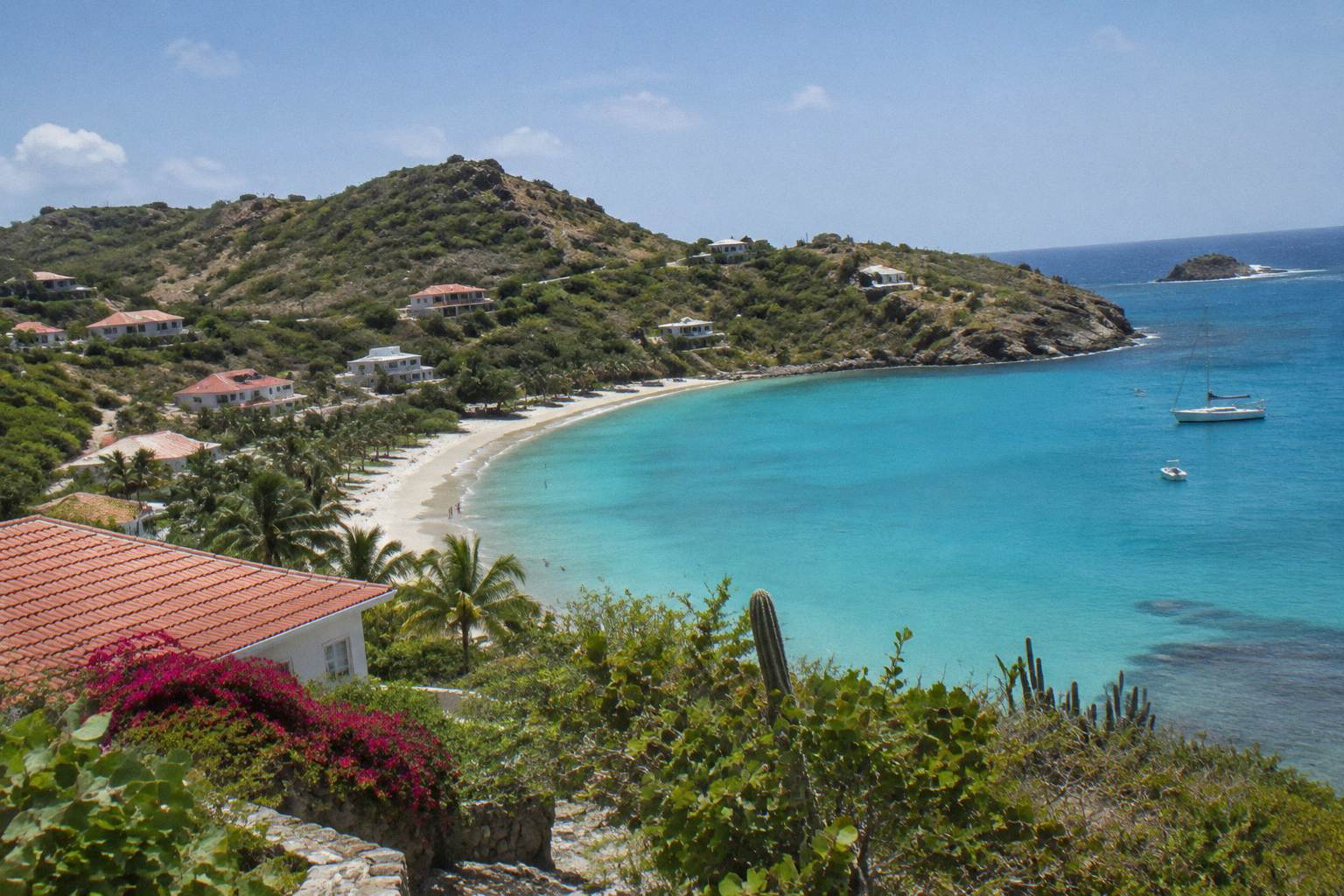 Turquoise bay with white sand beach and green hills in Saint Barthelemy