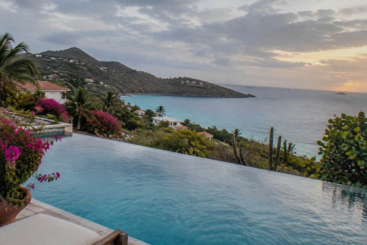 Infinity pool of a private villa overlooking the sea at dusk