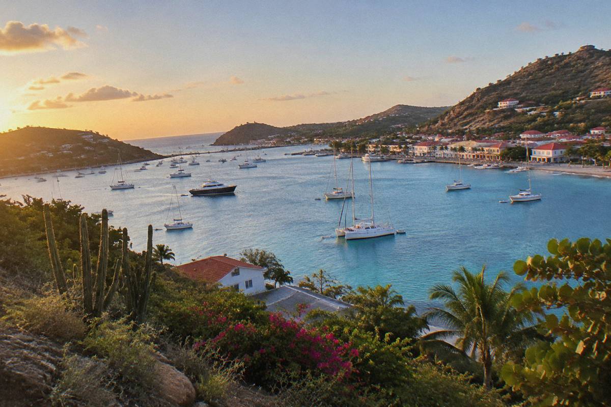 An evening view over Gustavia harbour with boats at anchor and warm light on the waterfront buildings.