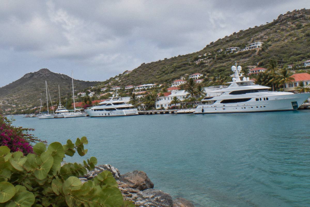 White superyachts moored along the Gustavia waterfront with hills behind