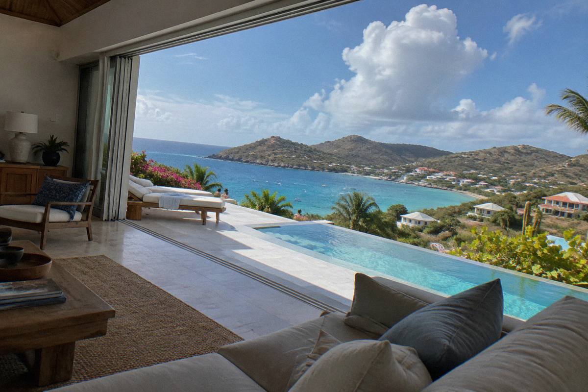 Modern villa living room with open sliding doors onto a pool terrace