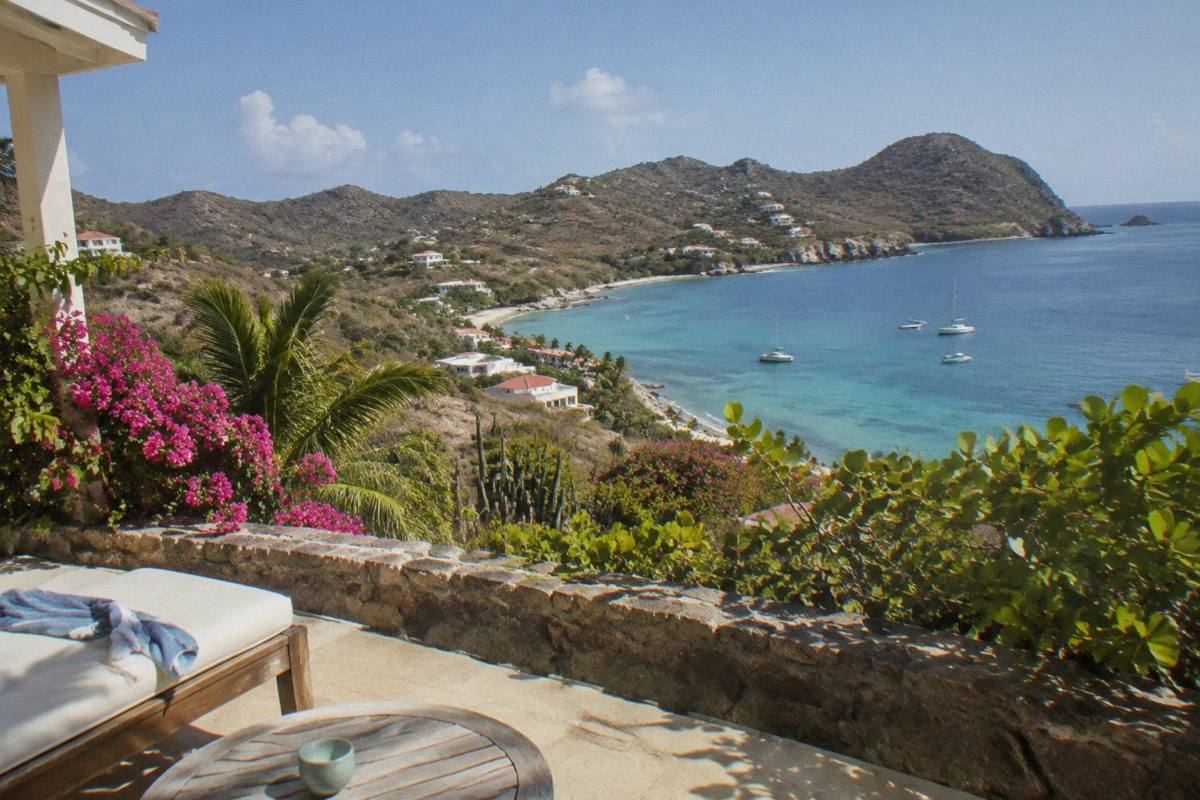 A quiet hotel terrace overlooking a bay with calm water