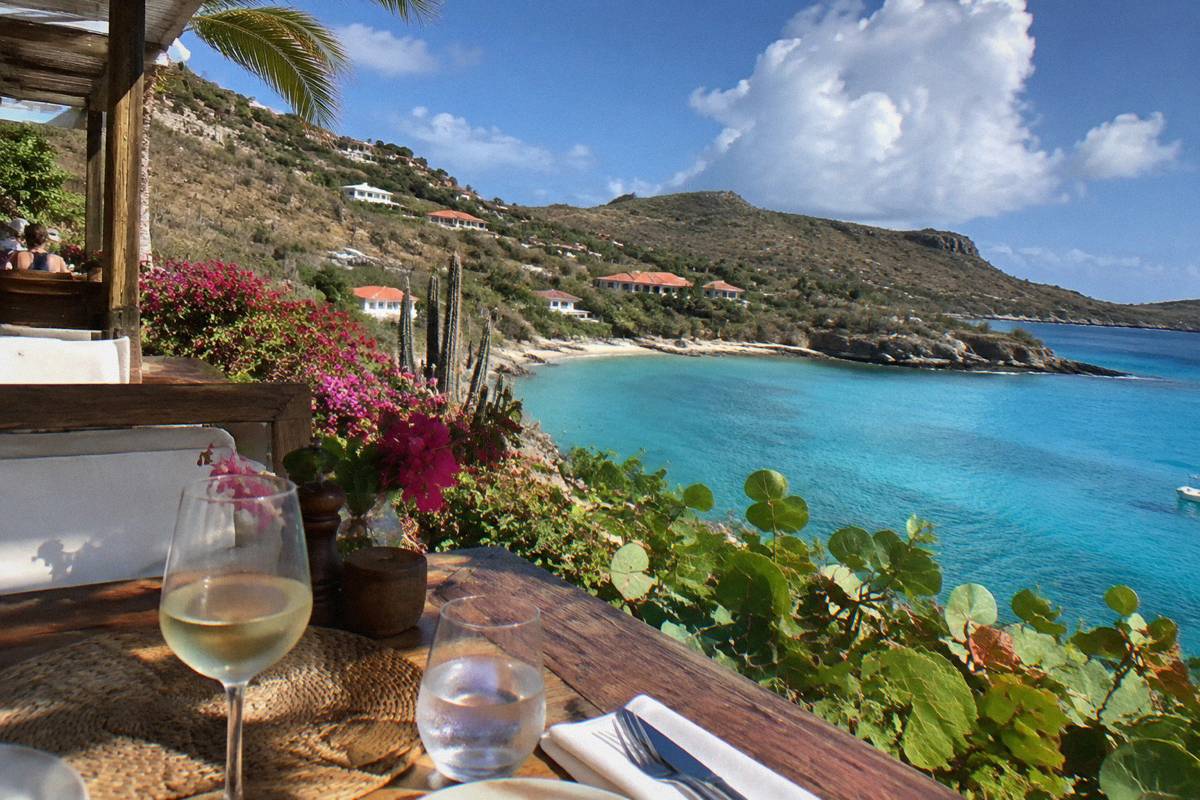 An open-air restaurant table beside the sea at a Caribbean hotel