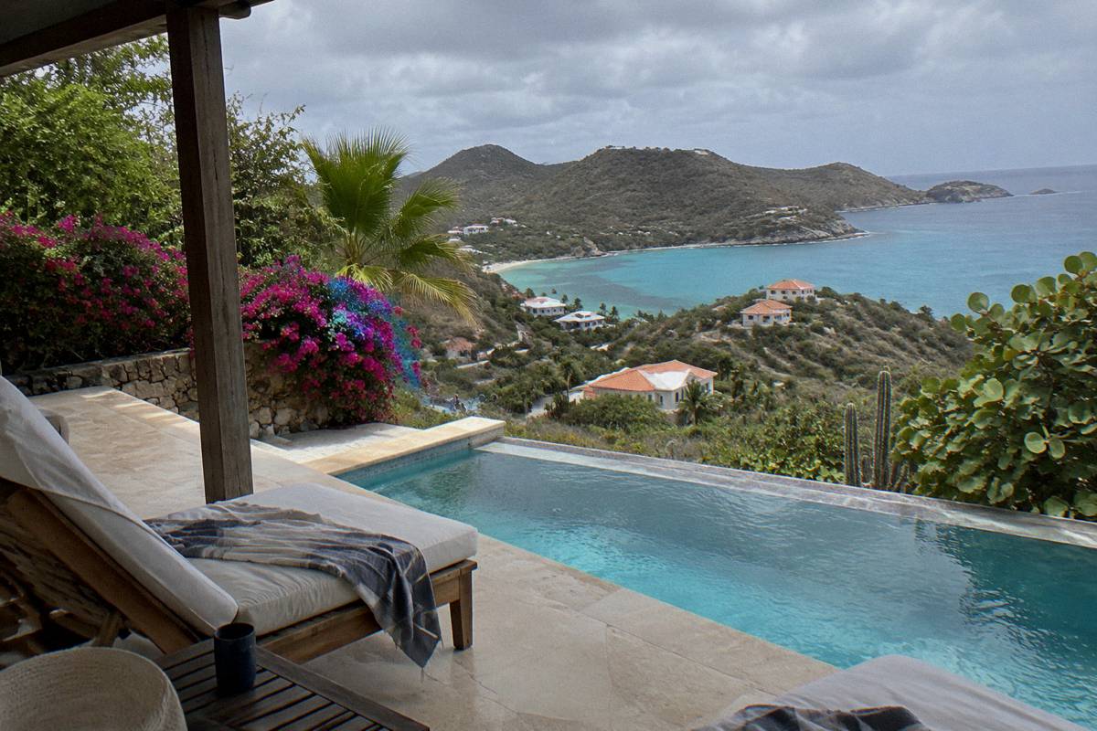 A shaded villa terrace with loungers beside a private pool