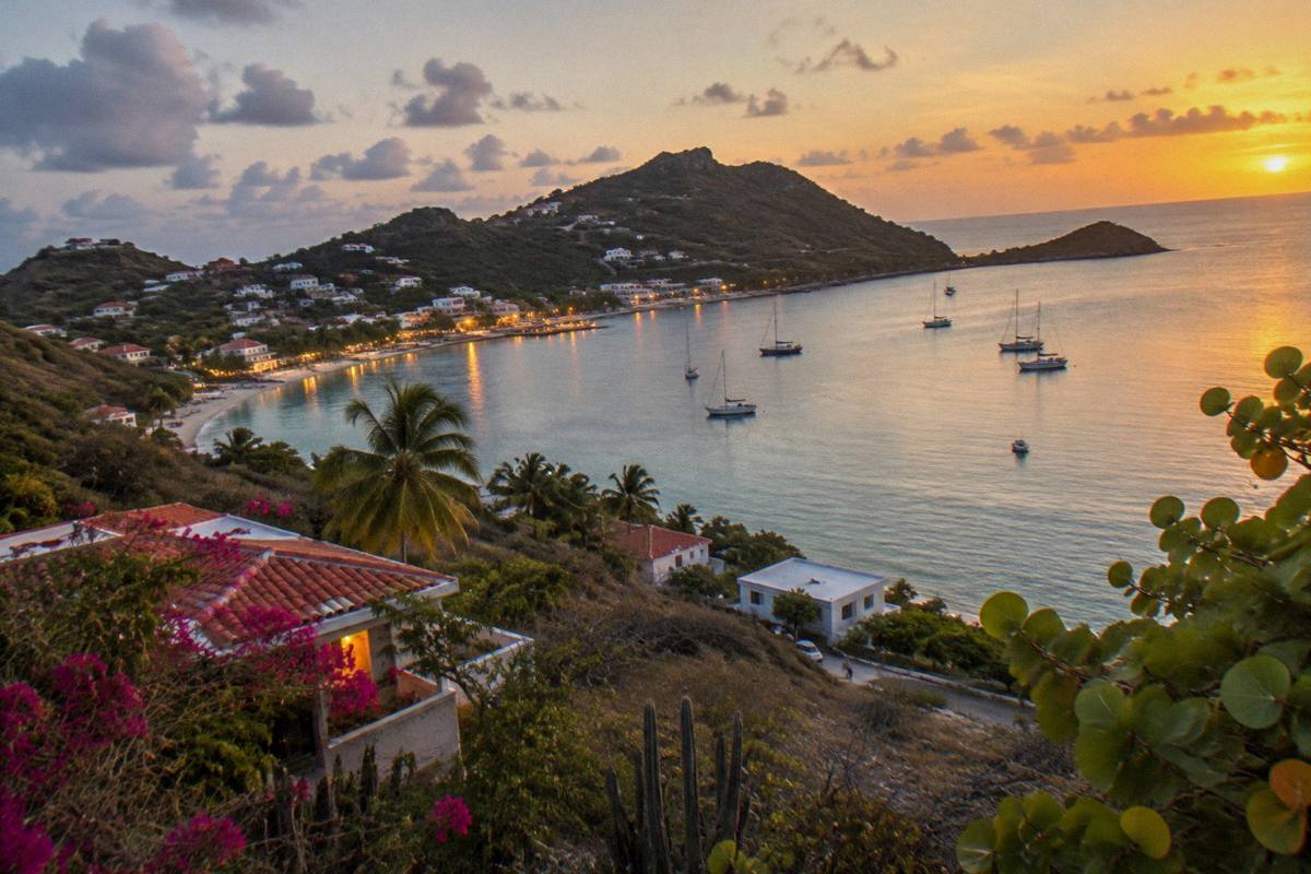 An evening view across a bay with lights reflecting on calm water