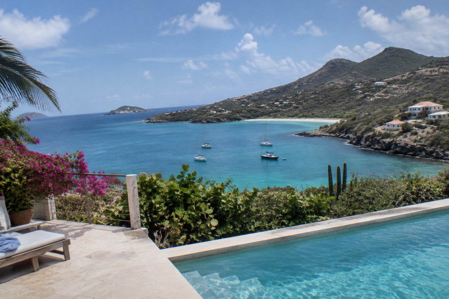 A villa terrace with a private pool overlooking a calm Caribbean bay