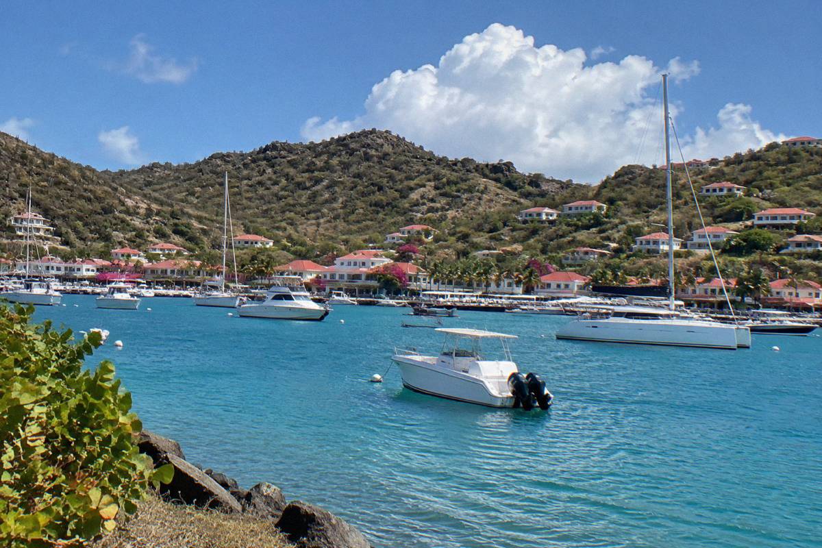 White boats anchored in Gustavia harbour beneath hillside houses