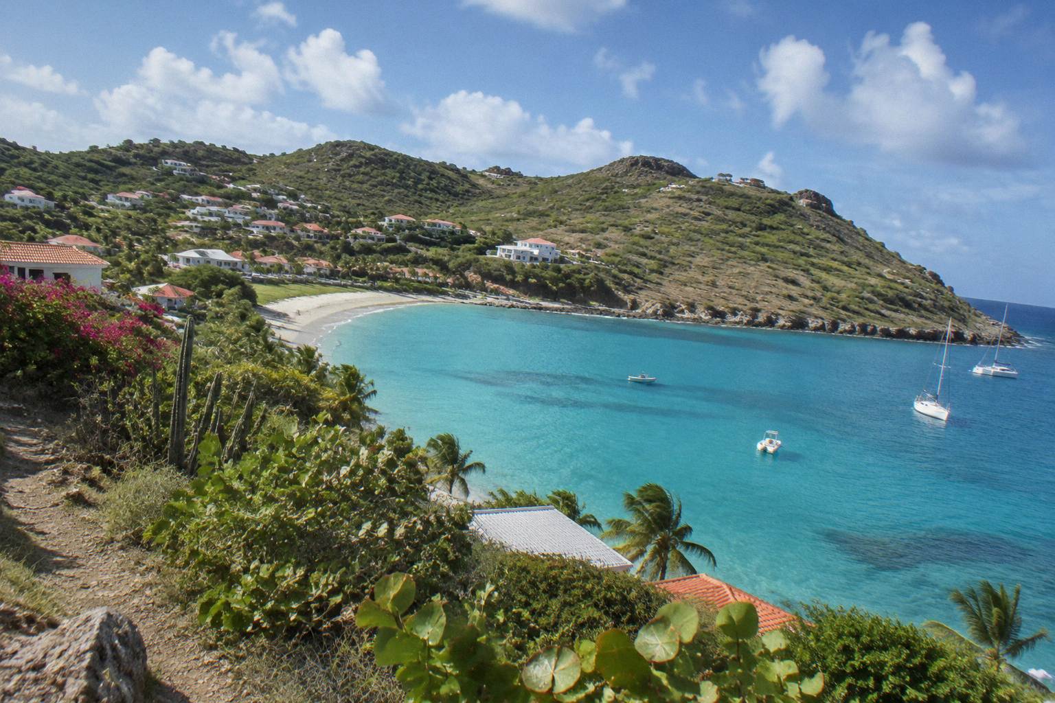 Quiet turquoise bay on St Barts with green hills above the shoreline