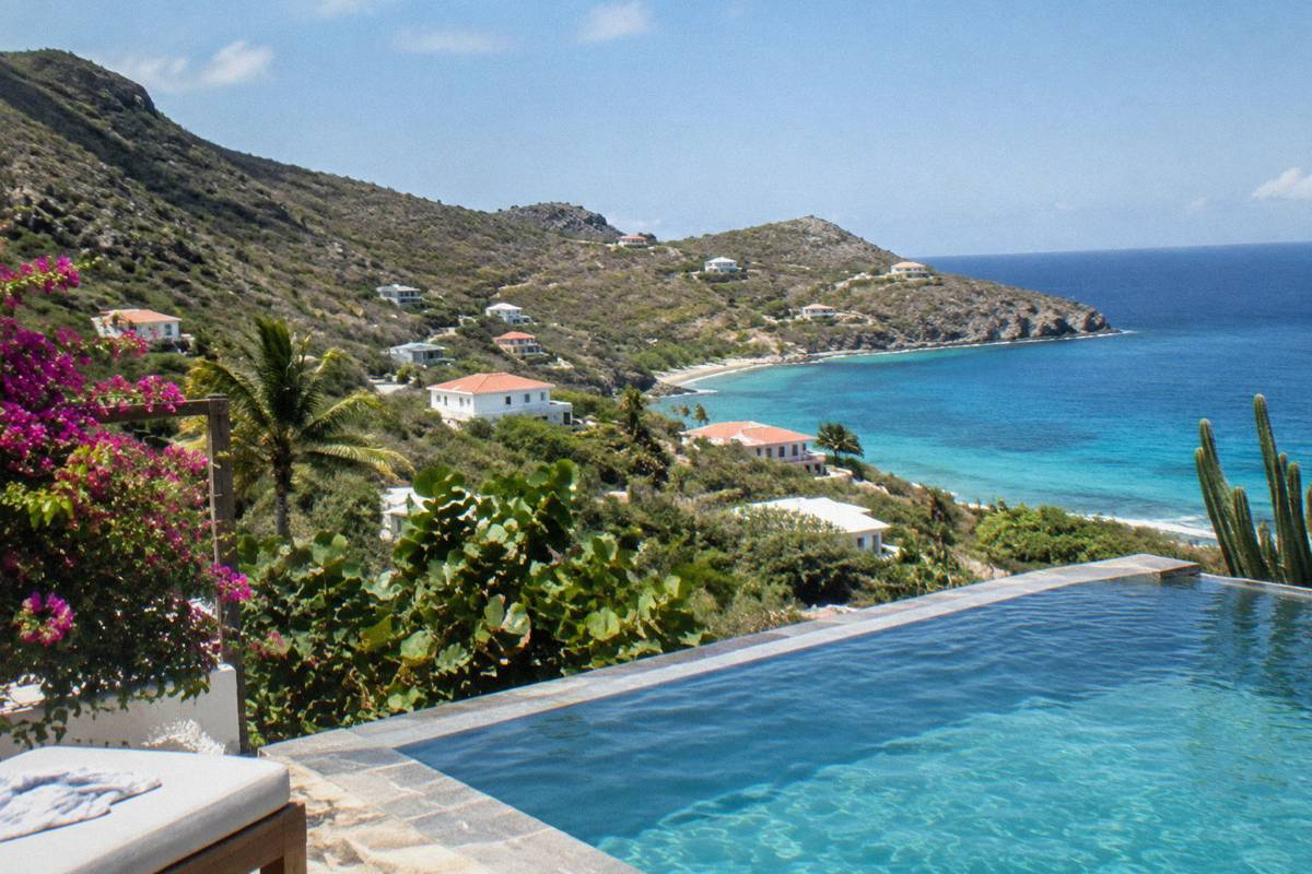 A quiet hillside infinity pool overlooking the Caribbean sea and green slopes