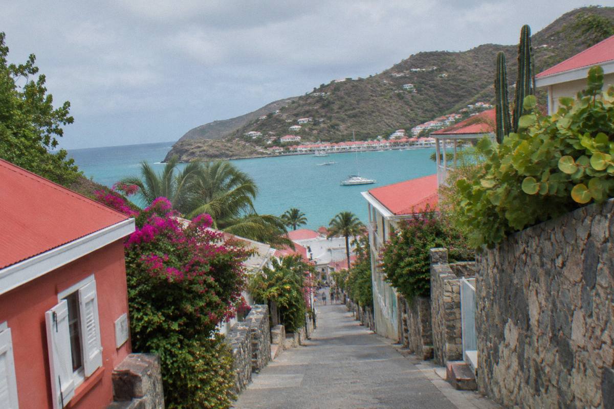 Colourful facades and stone walls on a narrow shopping street in Gustavia