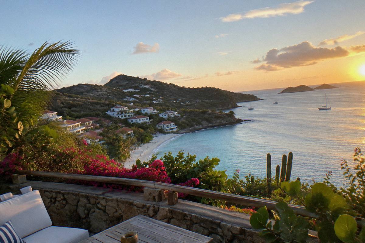 Beachfront terrace at sunset with calm water and a distant headland