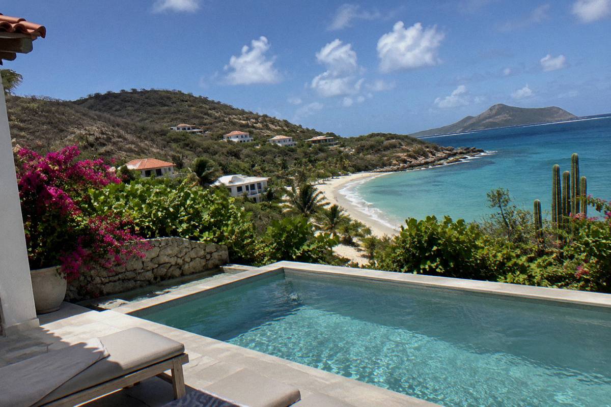 A private terrace with a small pool facing the sea and a sandy beach a few steps beyond