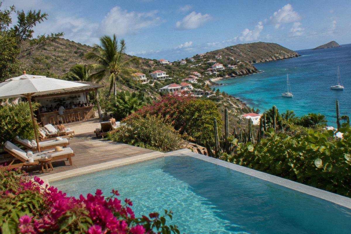 Boutique hotel pool deck with loungers and a small bar in the late afternoon