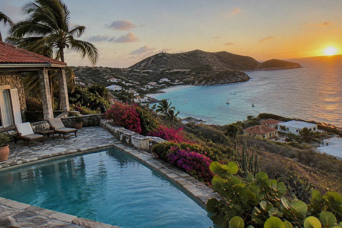 Stone villa terrace with pool and palm trees on a hillside