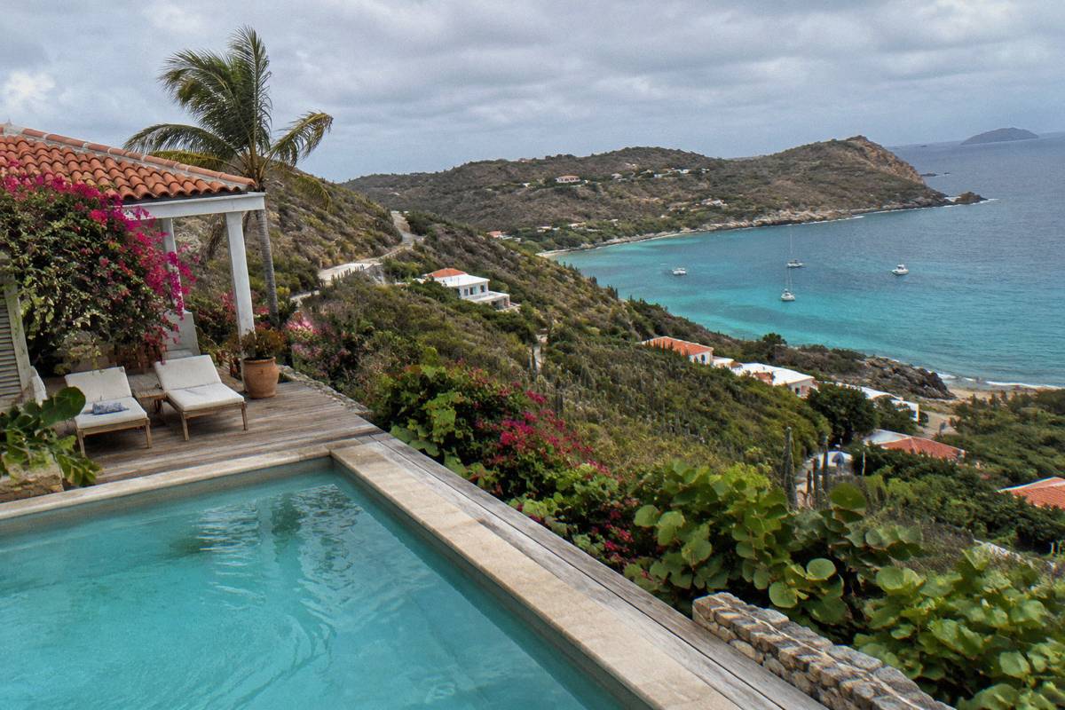 Hillside villa terrace with a private pool overlooking dark green coastline